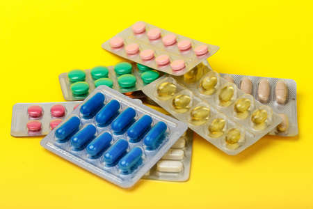 pharmaceutical medication and medicine pills in packs on yellow backgroundの写真素材