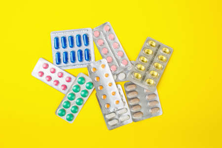 group of pharmaceutical medication and medicine pills in packs on yellow backgroundの写真素材