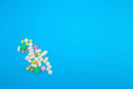 Heap of colorful pills on blue backgroundの写真素材