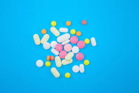 Heap of colorful pills on blue backgroundの写真素材