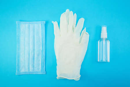 Horizontal top view of new hygiene items consisting of white latex gloves, face mask and hand...