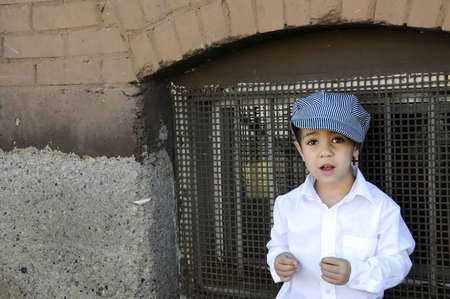 a small boy on the street with his hat onの写真素材