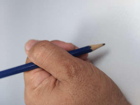A hand that holds a pencil for writing or drawing