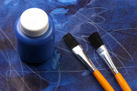 Water based paints and brush on a painted background.の写真素材