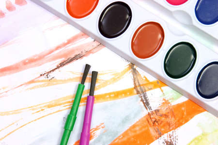 Watercolors and brushes on a painted background.の写真素材