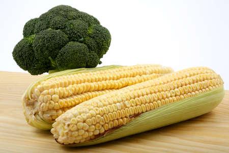 Vegetables, corn and broccoli on a table made of wood.の写真素材
