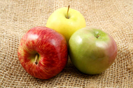 Trio of apples viewed from above laying over a rustic fabric.の写真素材