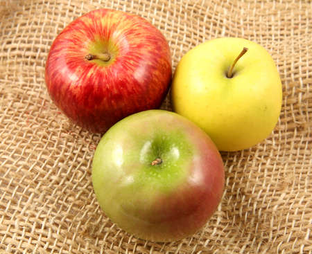 Trio of apples over a rustic fabric viewed from above.の写真素材