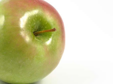Lateral appearing green apple in a horizontal view over a white background.の写真素材