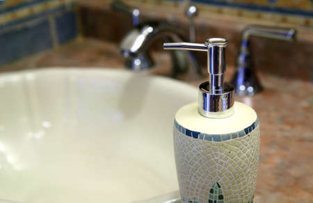 Trendy soap dispenser along a sink in a bathroom.の写真素材