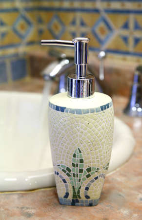 Trendy soap dispenser along a sink in a bathroom.の写真素材