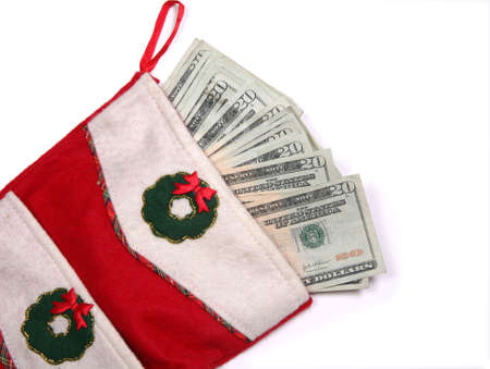 Christmas sock with season's details and money in it illustrating the concept of money spending.の写真素材