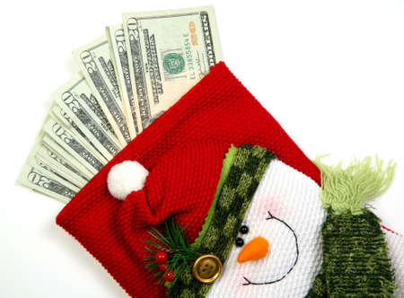 Christmas sock with season's details and money in it illustrating the concept of money spending.の写真素材