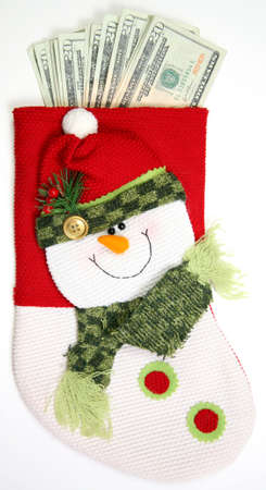 Christmas sock with season's details and money in it illustrating the concept of money spending.の写真素材
