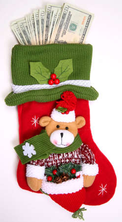 Christmas sock with season's details and money in it illustrating the concept of money spending.の写真素材