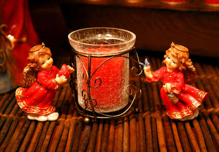 Angel figures-figurines with Christmas colors and a candle, decoration with warm light.の写真素材