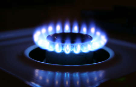 Bluish flames of a stove burner in total darkness illustrating combustion.の写真素材