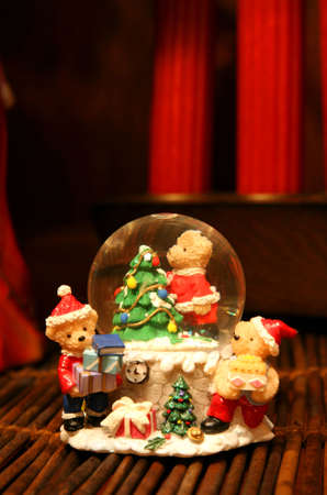 Teddy bears as Santa Factory in a water crystal sphere in a wooden area with warm light.の写真素材