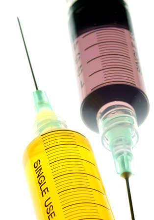 Back lighted image of a syringe containint colorful liquids for a high key effect.の写真素材