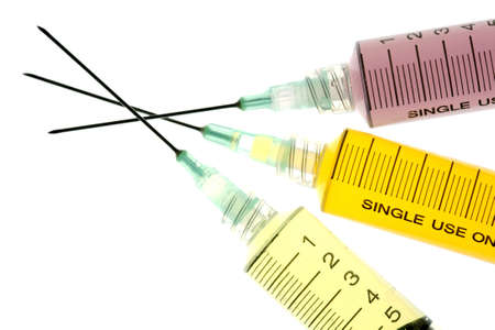 Back lighted image of a syringe containint colorful liquids for a high key effect.の写真素材