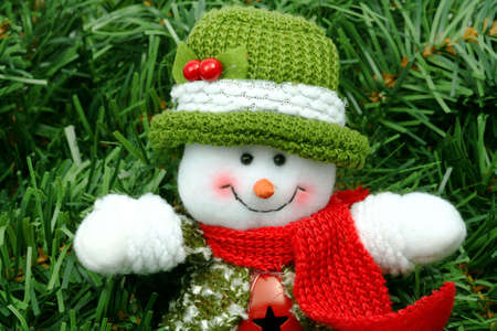Christmas generic snowman with a happy face on a green leaves bed.の写真素材