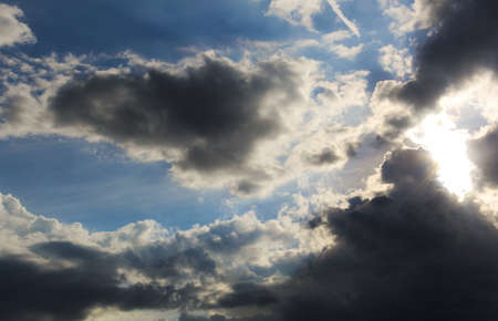 sun hidden by clouds, with rays of light filtering