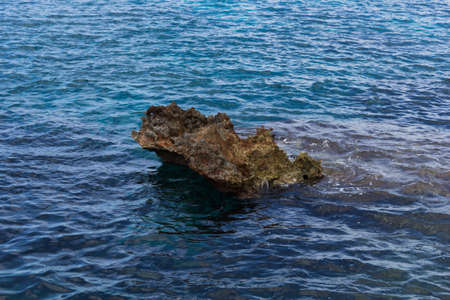 Photo of a cliff in the middle of the blue seaの写真素材