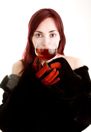 Beautiful girl in red gloves holding a glass of cognacの写真素材