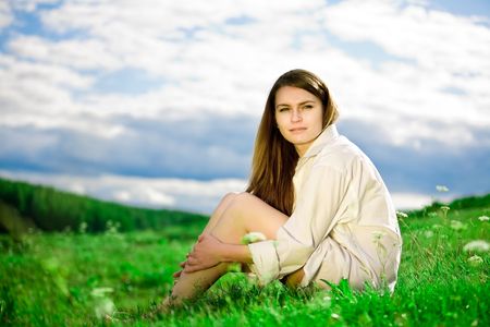 Young woman sitting in the grassの写真素材