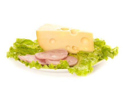 A plate of lettuce, maasdam and ham isolated on whiteの写真素材