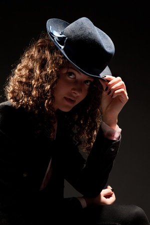 Beautiful curly-haired woman in fedora looking to the cameraの写真素材