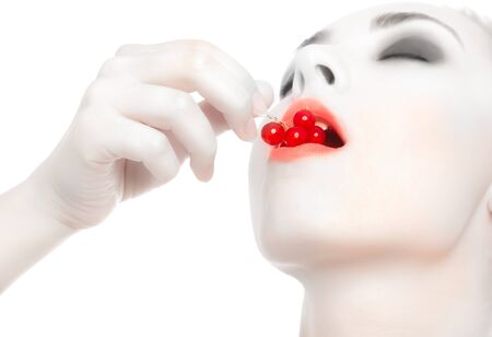 Sexy woman with red currant  in her lips isolated on white