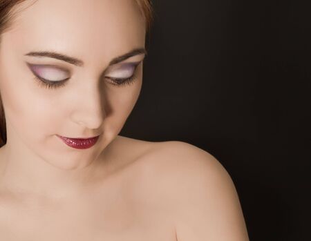 Beautiful woman with make up looking downの写真素材