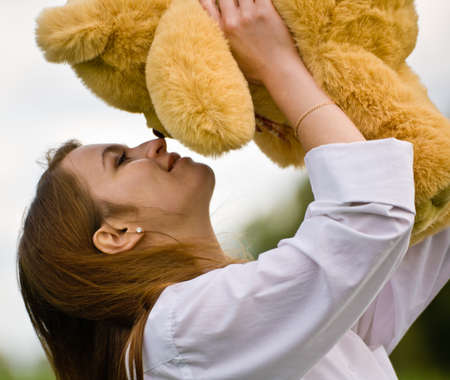 Woman with bear toy outdoorsの写真素材