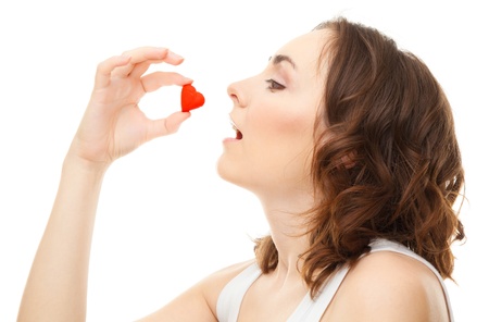 Young woman holding a heart isolated on whiteの写真素材