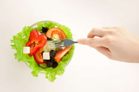 Picture of woman's hand with fork and greek saladの写真素材