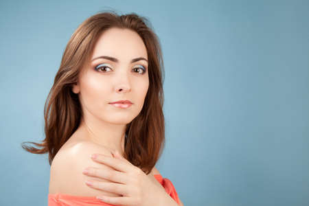 Portrait of beautiful woman with makeup on blue backgroundの写真素材
