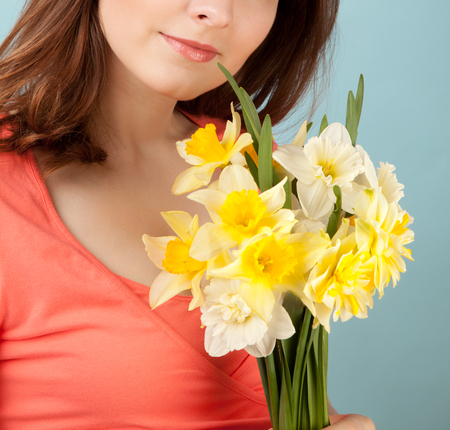 Beautiful woman with flowers on blue backgroundの写真素材