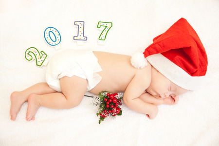 Baby lying in new year hat on white background