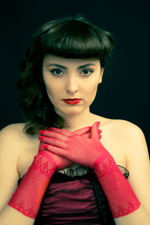 Beautiful woman with retro hairstyle looking directly to the cameraの写真素材