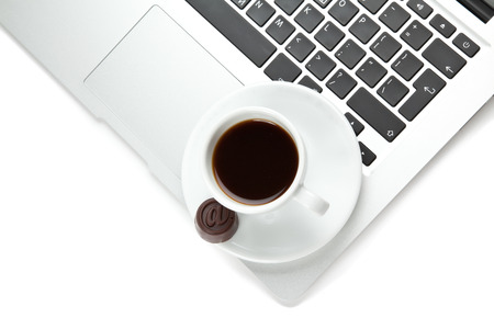 A cup of coffee and laptop on tableの写真素材
