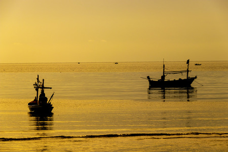 Fishing boats on the beach at sunsetの写真素材