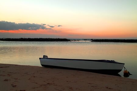 Boat on shore at sunsetの写真素材