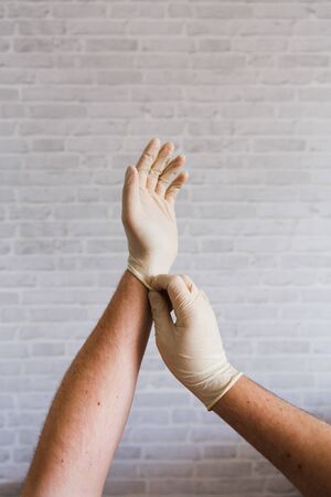 Hands putting on medical gloves for protectionの写真素材