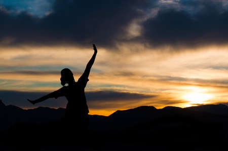 The woman who opened her arms is watching the sunset of the sun