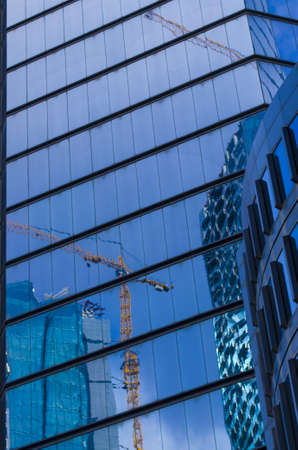 skyscraper construction and crane reflectionの写真素材