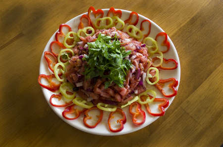 Salads and heart-shaped peppers on a wooden tableの写真素材