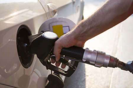 Hand holding fuel pump and refilling car at petrol stationの写真素材