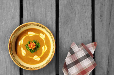 carrot cream soup on the wood tableの写真素材