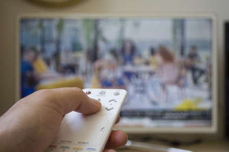 Man with remote control and flat tvの写真素材